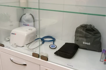 Тонометр, стетоскоп и другая медицинская аппаратура в шкафу